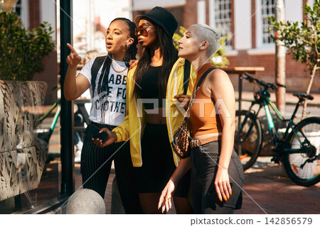 Woman, window and shopping with friends in city for fashion, style or summer clothing. Female person or group with outfit for discount, sale or pointing at special offer or deal in an urban town Woman, window and shopping with friends in city for fashion, style or summer clothing. Female person or group with outfit for discount, sale or pointing at special offer or deal in an urban town 142856579