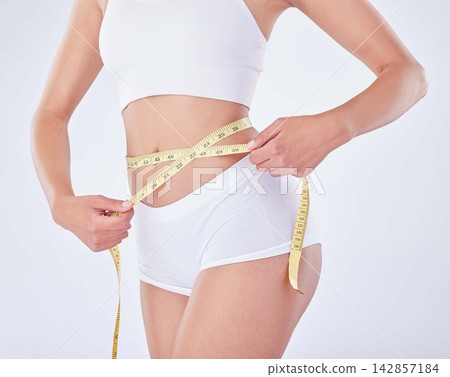 Hands, underwear and woman with tape measure on stomach for diet, nutrition or natural body. Weight loss, abdomen or slim model check skin for health and wellness isolated on white studio background Hands, underwear and woman with tape measure on stomach for diet, nutrition or natural body. Weight loss, abdomen or slim model check skin for health and wellness isolated on white studio background 142857184