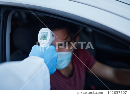 Man, car and temperature with infrared scanner for travel, immigration or commute in outdoor safety. Male person with mask in vehicle for test, exam or checking fever for virus, disease or infection Man, car and temperature with infrared scanner for travel, immigration or commute in outdoor safety. Male person with mask in vehicle for test, exam or checking fever for virus, disease or infection 142857307