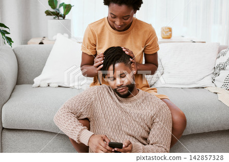 Couple, black woman and man in living room, phone and together for love, smile and romance in home to relax. House, African person and partner in lounge, touch and happy for marriage and commitment Couple, black woman and man in living room, phone and together for love, smile and romance in home to relax. House, African person and partner in lounge, touch and happy for marriage and commitment 142857328