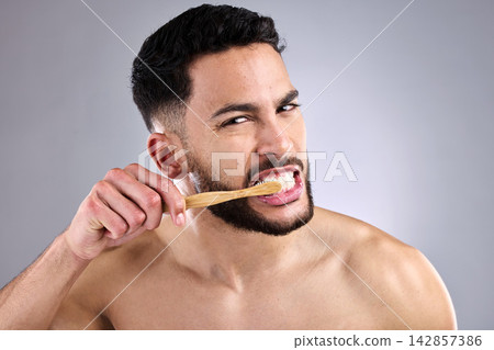 Portrait, man and toothbrush in studio background for oral hygiene, cleaning mouth and medical wellness. Male person, fresh and bamboo isolated for dental care, grooming and cavity prevention Portrait, man and toothbrush in studio background for oral hygiene, cleaning mouth and medical wellness. Male person, fresh and bamboo isolated for dental care, grooming and cavity prevention 142857386