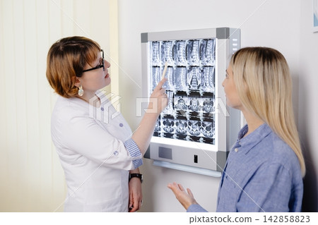 Doctor explaining spinal MRI results to patient 142858823