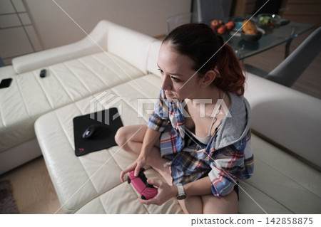 Focused teenage gamer with controller represents autonomy persistence problem solving and the psychological transition from dependence toward independent choices Focused teenage gamer with controller represents autonomy persistence problem solving and the psychological transition from dependence toward independent choices 142858875