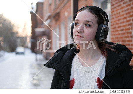 Independent teenage girl wearing headphones outdoors represents personal space self identity emotional autonomy and freedom during the transition to adulthood Independent teenage girl wearing headphones outdoors represents personal space self identity emotional autonomy and freedom during the transition to adulthood 142858879