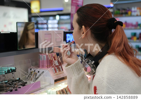 Independent teenage girl choosing lipstick in beauty store explores personal identity confidence self expression and freedom of everyday choice Independent teenage girl choosing lipstick in beauty store explores personal identity confidence self expression and freedom of everyday choice 142858889