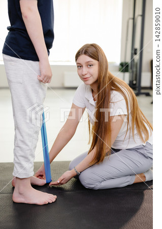 Physiotherapist examining posture of young patient in rehabilitation center Physiotherapist examining posture of young patient in rehabilitation center 142859010