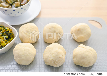 Rolling the dough for homemade oyaki and preparing the filling. Rolling the dough for homemade oyaki and preparing the filling. 142859089