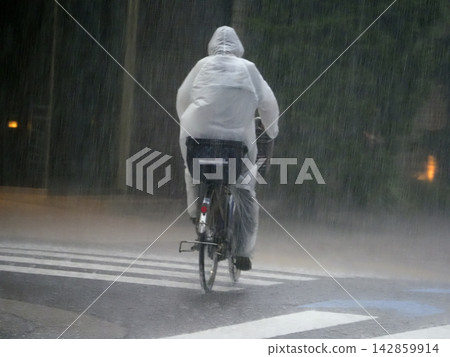 People riding bicycles in the rain People riding bicycles in the rain 142859914