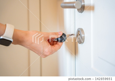 Hand using an RFID key fob to unlock an apartment door with electronic access system. Concept of keyless entry, smart security and modern access control. Hand using an RFID key fob to unlock an apartment door with electronic access system. Concept of keyless entry, smart security and modern access control. 142859931
