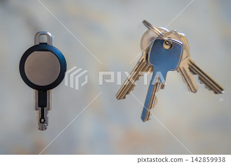 Traditional metal keys next to an RFID key fob on a white background. Concept of transition from mechanical locks to electronic access control and smart security. Traditional metal keys next to an RFID key fob on a white background. Concept of transition from mechanical locks to electronic access control and smart security. 142859938