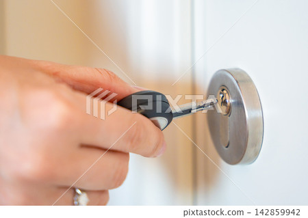 Close up view of hand using an RFID key fob to unlock an apartment door with electronic access system. Concept of keyless entry, smart security and modern access control. Close up view of hand using an RFID key fob to unlock an apartment door with electronic access system. Concept of keyless entry, smart security and modern access control. 142859942