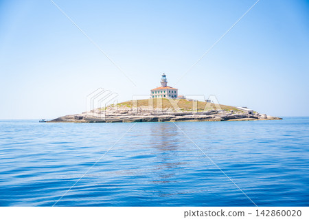 Porer Lighthouse on Porer Islet near Cape Kamenjak in Istria Croatia on the Adriatic Sea. Historic lighthouse guiding maritime navigation along the rocky coast. Porer Lighthouse on Porer Islet near Cape Kamenjak in Istria Croatia on the Adriatic Sea. Historic lighthouse guiding maritime navigation along the rocky coast. 142860020