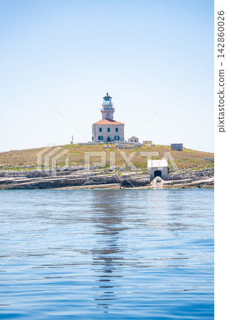 Porer Lighthouse on Porer Islet near Cape Kamenjak in Istria Croatia on the Adriatic Sea. Historic lighthouse guiding maritime navigation along the rocky coast. Porer Lighthouse on Porer Islet near Cape Kamenjak in Istria Croatia on the Adriatic Sea. Historic lighthouse guiding maritime navigation along the rocky coast. 142860026