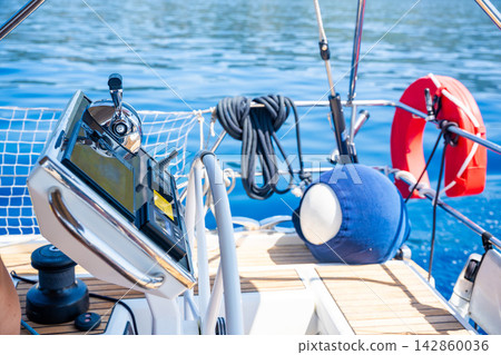 Modern yacht helm station with GPS chartplotter and engine control at sea. Advanced marine navigation technology for safe sailing and vessel operation. 142860036
