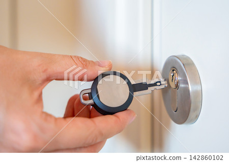 Close up view of hand using an RFID key fob to unlock an apartment door with electronic access system. Concept of keyless entry, smart security and modern access control. Close up view of hand using an RFID key fob to unlock an apartment door with electronic access system. Concept of keyless entry, smart security and modern access control. 142860102