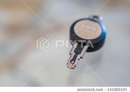 Close up of an RFID key fob with a visible electronic contact chip on a white background. Concept of electronic authentication, secure access and digital identification technology. Close up of an RFID key fob with a visible electronic contact chip on a white background. Concept of electronic authentication, secure access and digital identification technology. 142860104