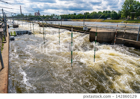 Artificial whitewater slalom course with numbered gates on the Vltava River in Prague Czech Republic. Outdoor kayaking training and canoe slalom concept for water sports and active recreation. Artificial whitewater slalom course with numbered gates on the Vltava River in Prague Czech Republic. Outdoor kayaking training and canoe slalom concept for water sports and active recreation. 142860129
