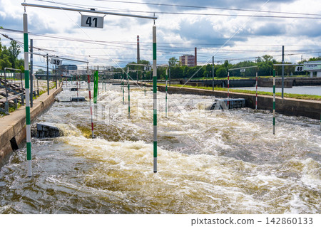 Artificial whitewater slalom course with numbered gates on the Vltava River in Prague Czech Republic. Outdoor kayaking training and canoe slalom concept for water sports and active recreation. Artificial whitewater slalom course with numbered gates on the Vltava River in Prague Czech Republic. Outdoor kayaking training and canoe slalom concept for water sports and active recreation. 142860133