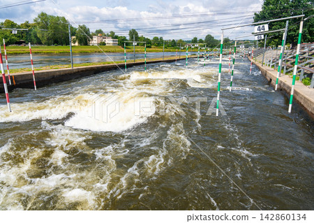 Artificial whitewater slalom course with numbered gates on the Vltava River in Prague Czech Republic. Outdoor kayaking training and canoe slalom concept for water sports and active recreation. 142860134