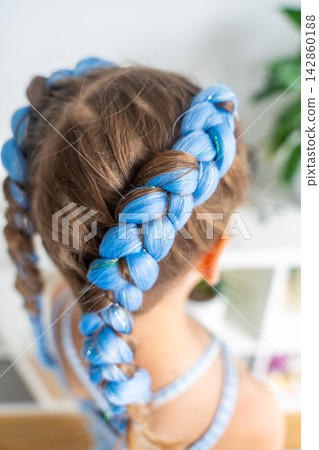 Colorful blue synthetic hair extensions braided into a young girl hairstyle. Trendy protective styling highlights creativity self expression and Generation Alpha fashion Colorful blue synthetic hair extensions braided into a young girl hairstyle. Trendy protective styling highlights creativity self expression and Generation Alpha fashion 142860188
