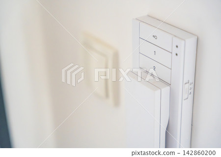 Close up of a home intercom control panel on a wall near an apartment entrance. Residential access control concept for security, communication and visitor management. 142860200