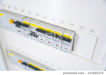 Electrical circuit breaker panel with switched breakers inside a residential distribution board. Electrical safety and power management support maintenance and infrastructure reliability. Electrical circuit breaker panel with switched breakers inside a residential distribution board. Electrical safety and power management support maintenance and infrastructure reliability. 142860254