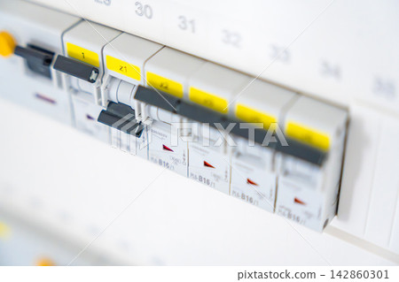Electrical circuit breaker panel with switched breakers inside a residential distribution board. Electrical safety and power management support maintenance and infrastructure reliability. 142860301