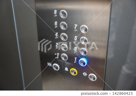 Elevator control panel with the first floor button illuminated inside a residential building. Clear floor selection supports convenient navigation and accessible everyday mobility Elevator control panel with the first floor button illuminated inside a residential building. Clear floor selection supports convenient navigation and accessible everyday mobility 142860423