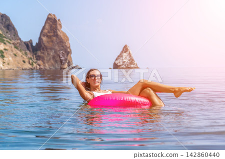 Woman relaxing floating, vacation summer resort travel beach sea rocks cliffs background Woman relaxing floating, vacation summer resort travel beach sea rocks cliffs background 142860440