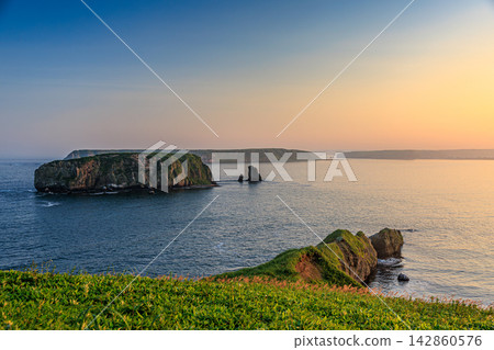 A breathtaking view of Cape Azechi in Hamanaka Town, Hokkaido, bathed in the golden hues of sunset. 142860576