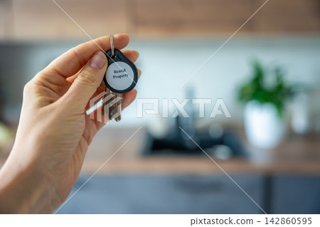 Woman holding house keys with rental property keychain inside modern apartment interior. Real estate investment and passive income concept for landlords and property business Woman holding house keys with rental property keychain inside modern apartment interior. Real estate investment and passive income concept for landlords and property business 142860595