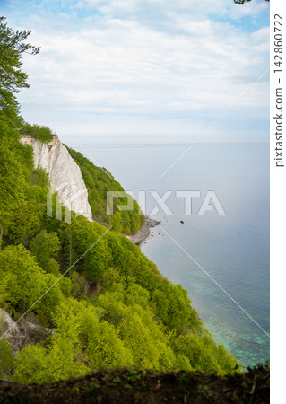 View of famous white chalk cliffs in Jasmund National Park on Rugen island, Germany. Scenic Baltic Sea coastline from forest trail View of famous white chalk cliffs in Jasmund National Park on Rugen island, Germany. Scenic Baltic Sea coastline from forest trail 142860722