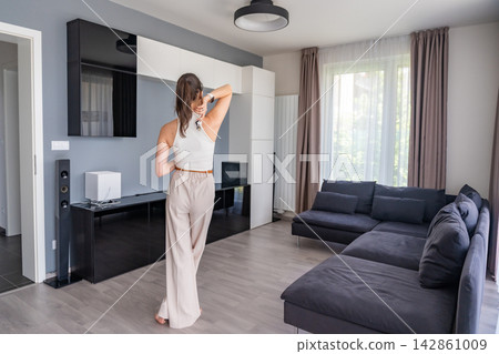 Young woman with apartment keys standing in furnished resale apartment interior. Secondary housing purchase and moving into existing property concept Young woman with apartment keys standing in furnished resale apartment interior. Secondary housing purchase and moving into existing property concept 142861009