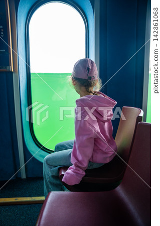 Little girl looking through underwater windows inside the diving gondola at Sellin Pier on Rugen island, Germany. Childhood curiosity and marine discovery concept. Little girl looking through underwater windows inside the diving gondola at Sellin Pier on Rugen island, Germany. Childhood curiosity and marine discovery concept. 142861068