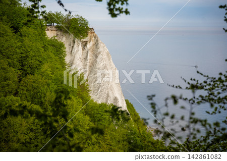 View of famous white chalk cliffs in Jasmund National Park on Rugen island, Germany. Scenic Baltic Sea coastline from forest trail View of famous white chalk cliffs in Jasmund National Park on Rugen island, Germany. Scenic Baltic Sea coastline from forest trail 142861082
