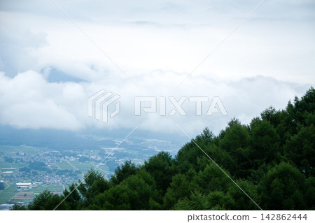 A town nestled in the mountains, shrouded in mist A town nestled in the mountains, shrouded in mist 142862444