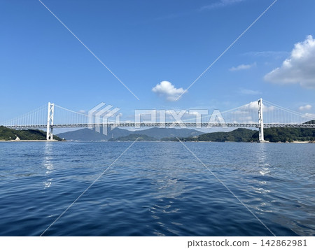 因島大橋橫跨瀨戶內海,以藍天為背景,展現出壯麗的全景(島波海道、因島、向島、尾道、懸索橋、基礎設施、背景素材) 因島大橋橫跨瀨戶內海,以藍天為背景,展現出壯麗的全景(島波海道、因島、向島、尾道、懸索橋、基礎設施、背景素材) 142862981