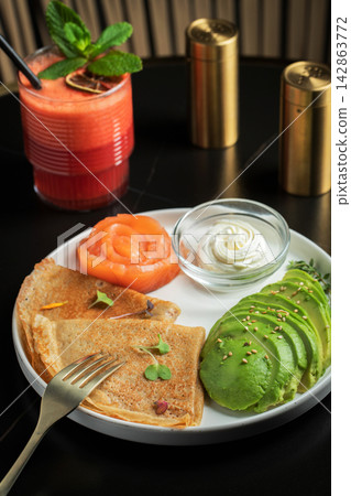 Roasted thin pancakes with smoked salmon and sauce Roasted thin pancakes with smoked salmon and sauce 142863772