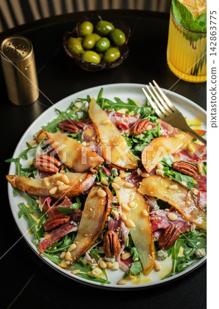 Salad with Pear, Arugula, Jamon, Blue Cheese and Blueberry, Delicious Fresh Salad Appetizer on Bright Background Salad with Pear, Arugula, Jamon, Blue Cheese and Blueberry, Delicious Fresh Salad Appetizer on Bright Background 142863775