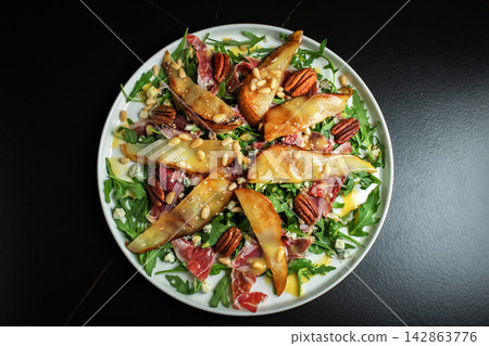 Salad with Pear, Arugula, Jamon, Blue Cheese and Blueberry, Delicious Fresh Salad Appetizer on Bright Background 142863776