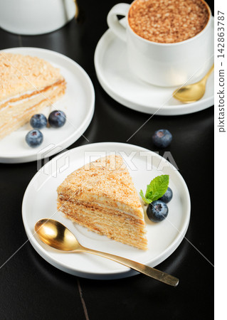 Medovik. Honey cake made from honey cakes with whipped sour cream, decorated with berries, pomegranate and flowers Medovik. Honey cake made from honey cakes with whipped sour cream, decorated with berries, pomegranate and flowers 142863787