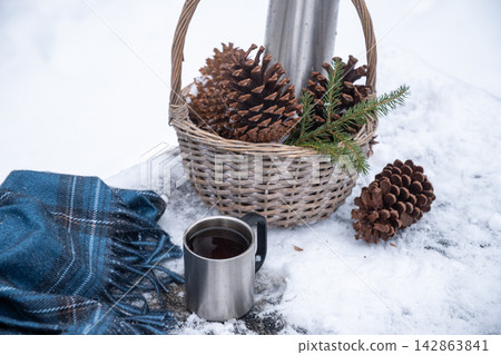 Winter picnic basket with thermos and pine cones Winter picnic basket with thermos and pine cones 142863841