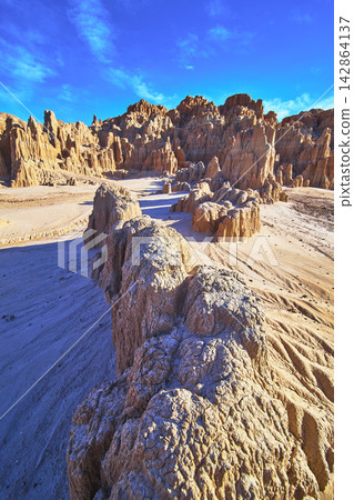 Eroded Clay Formations and Desert Terrain under Blue Sky in Cathedral Gorge State Park Eroded Clay Formations and Desert Terrain under Blue Sky in Cathedral Gorge State Park 142864137