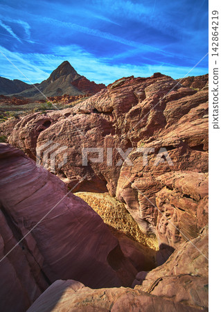 Red Rock Formations and Desert Mountain Under Vivid Blue Sky in Scenic Nevada Landscape Red Rock Formations and Desert Mountain Under Vivid Blue Sky in Scenic Nevada Landscape 142864219