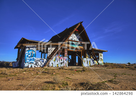 Abandoned Graffiti Covered Building Desert Landscape and Blue Sky in California Abandoned Graffiti Covered Building Desert Landscape and Blue Sky in California 142864298