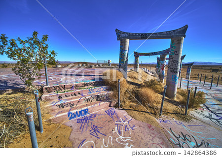 Abandoned Graffiti Covered Water Park Ruins in California Desert Under Blue Sky Abandoned Graffiti Covered Water Park Ruins in California Desert Under Blue Sky 142864386