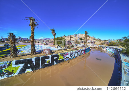Abandoned Graffiti Water Park with Palm Trees and Desert Landscape in California Abandoned Graffiti Water Park with Palm Trees and Desert Landscape in California 142864512