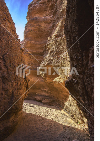 Slot Canyon Sunlit Walls and Sandy Floor in Desert Landscape Slot Canyon Sunlit Walls and Sandy Floor in Desert Landscape 142864587
