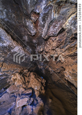 Lava Tube Interior With Volcanic Rock Formations and Shadowed Cavern Ceiling Lava Tube Interior With Volcanic Rock Formations and Shadowed Cavern Ceiling 142864649
