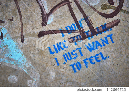 Graffiti Texture on Abandoned Concrete with Blue Stenciled Urban Text Art Graffiti Texture on Abandoned Concrete with Blue Stenciled Urban Text Art 142864713